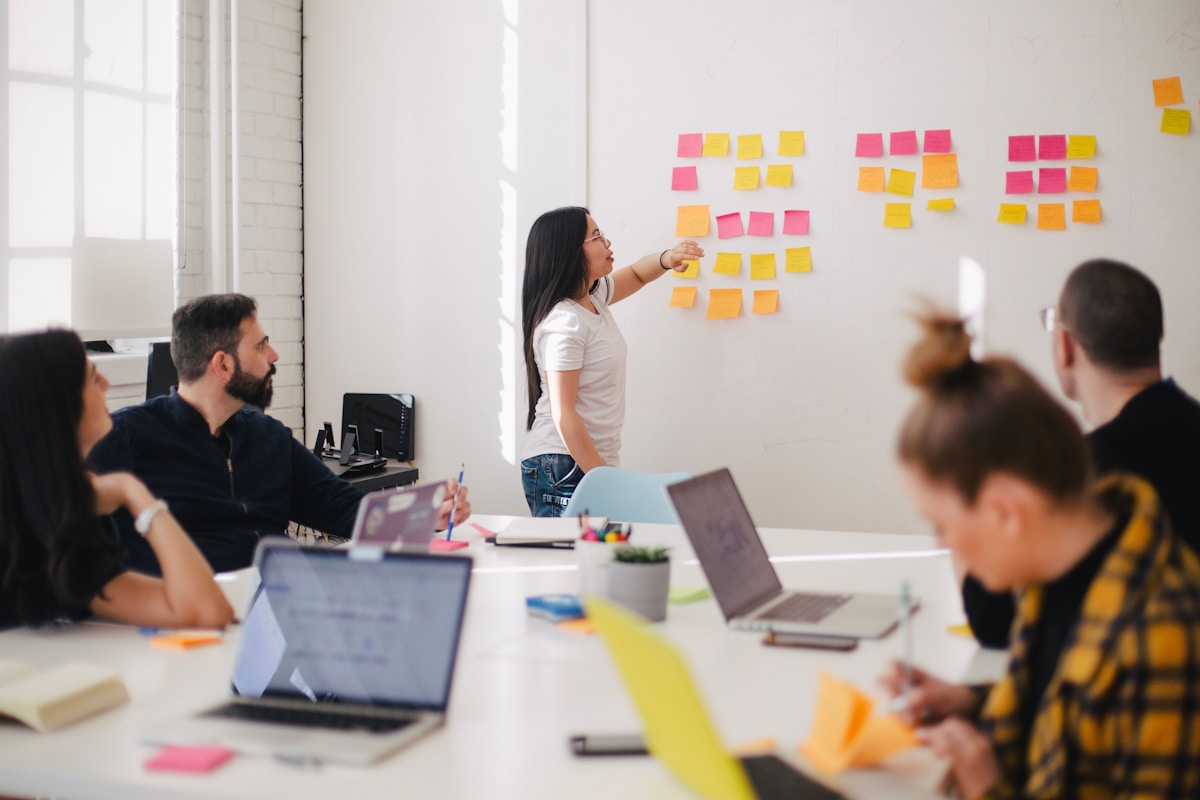 A team gathered around a whiteboard of sticky notes, planning together